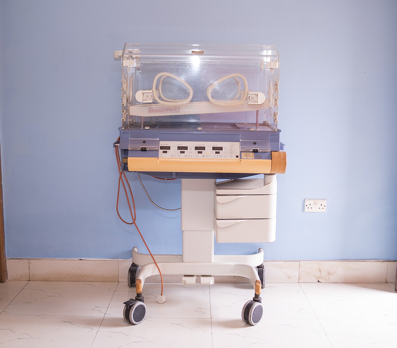 Empty infant incubator on a wheeled stand