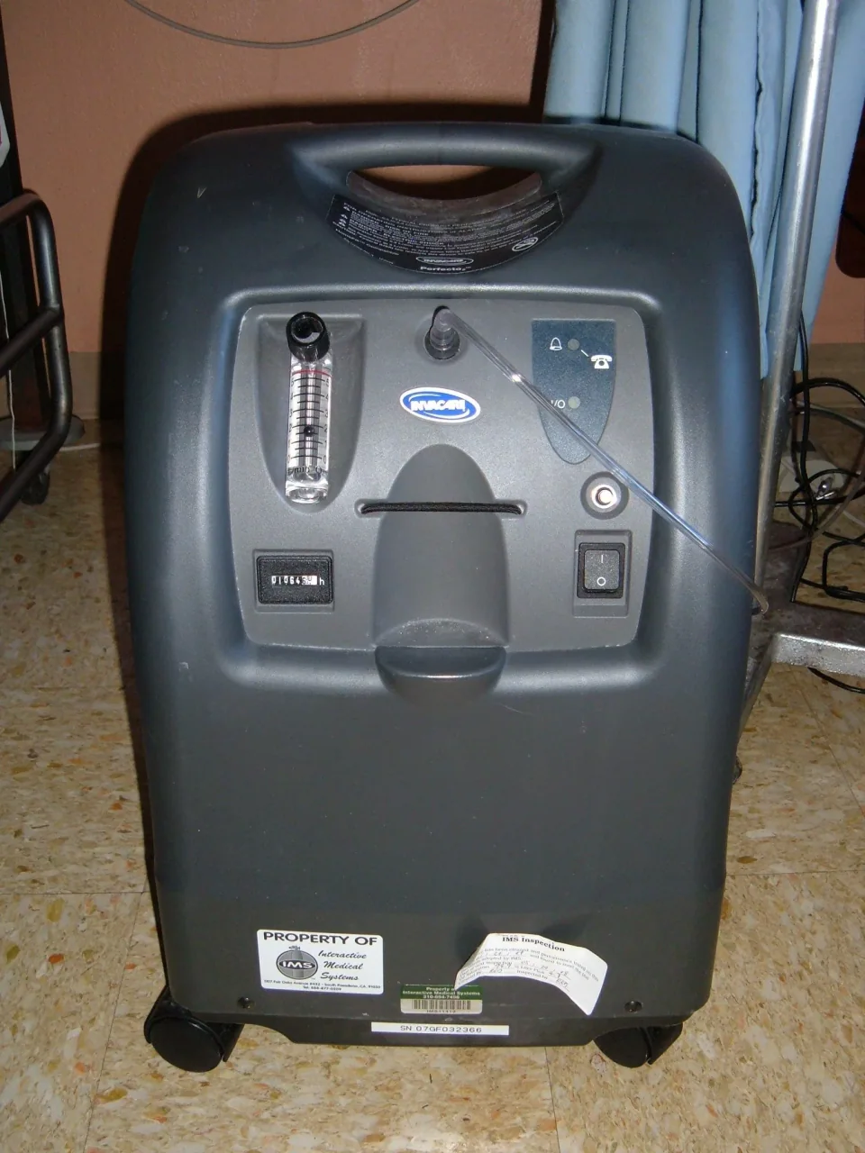 Invacare Perfecto 2 oxygen concentrator with a flow meter and controls on its front panel.