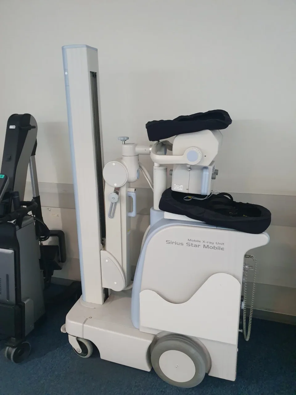 A Sirius Star Mobile X-ray machine with its tube arm folded over the wheeled base.
