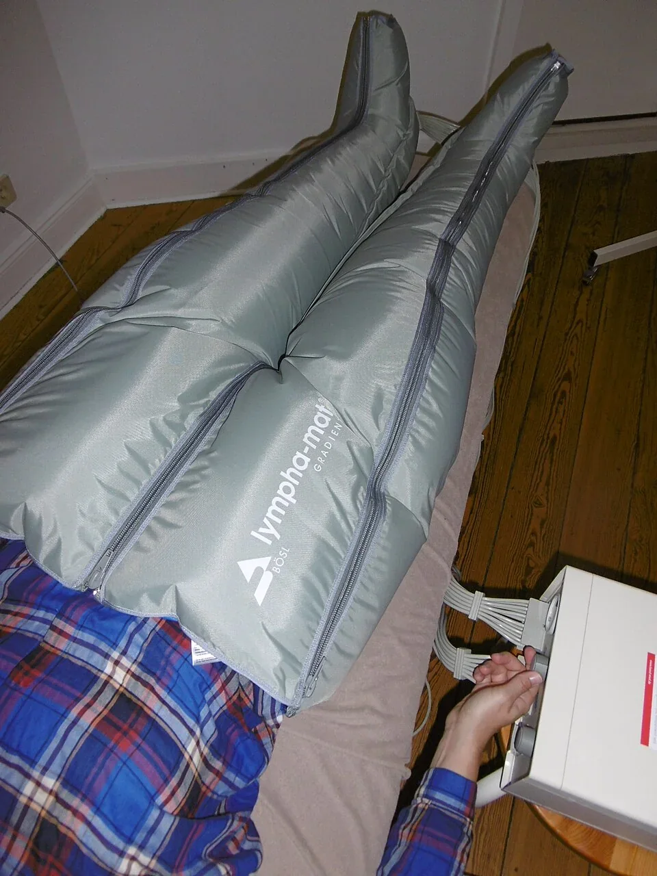 A full-leg Lymphopress pneumatic compression garment covering a reclining person’s legs.