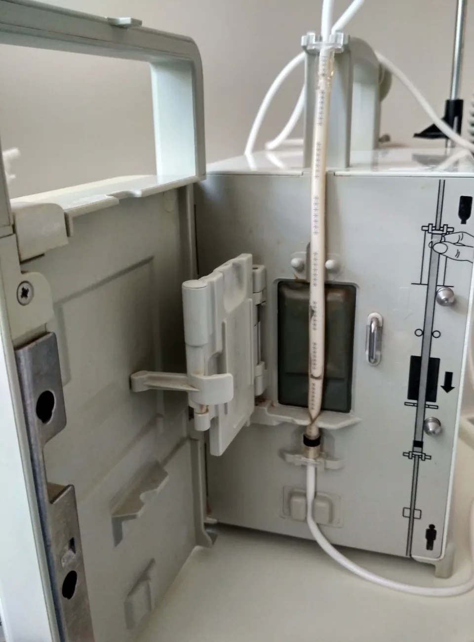 An open B. Braun Infusomat infusion pump showing the loaded tubing path and door.