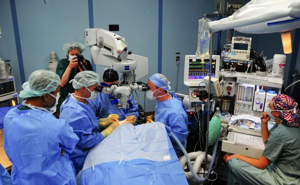 Surgeons using a ZEISS operating microscope in an operating room aboard a hospital ship.