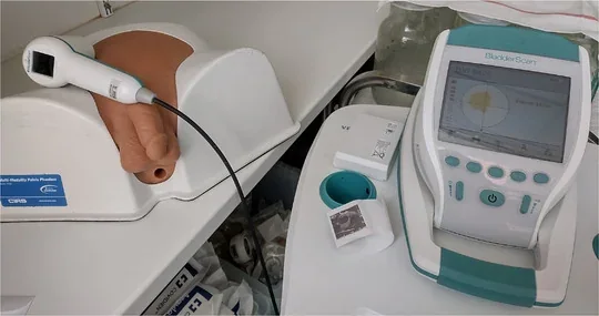 BladderScan BVI 9400 console and probe beside a CIRS bladder testing phantom
