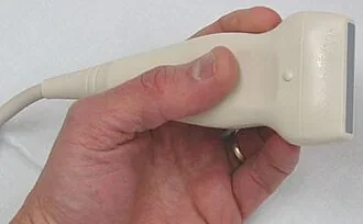 A hand holding a flat linear-array ultrasound transducer.